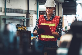 Manufacturing worker working with clipboard to do job procedure checklist