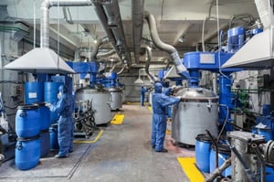 Workers in Blue Protective Suits at a Chemical Plant